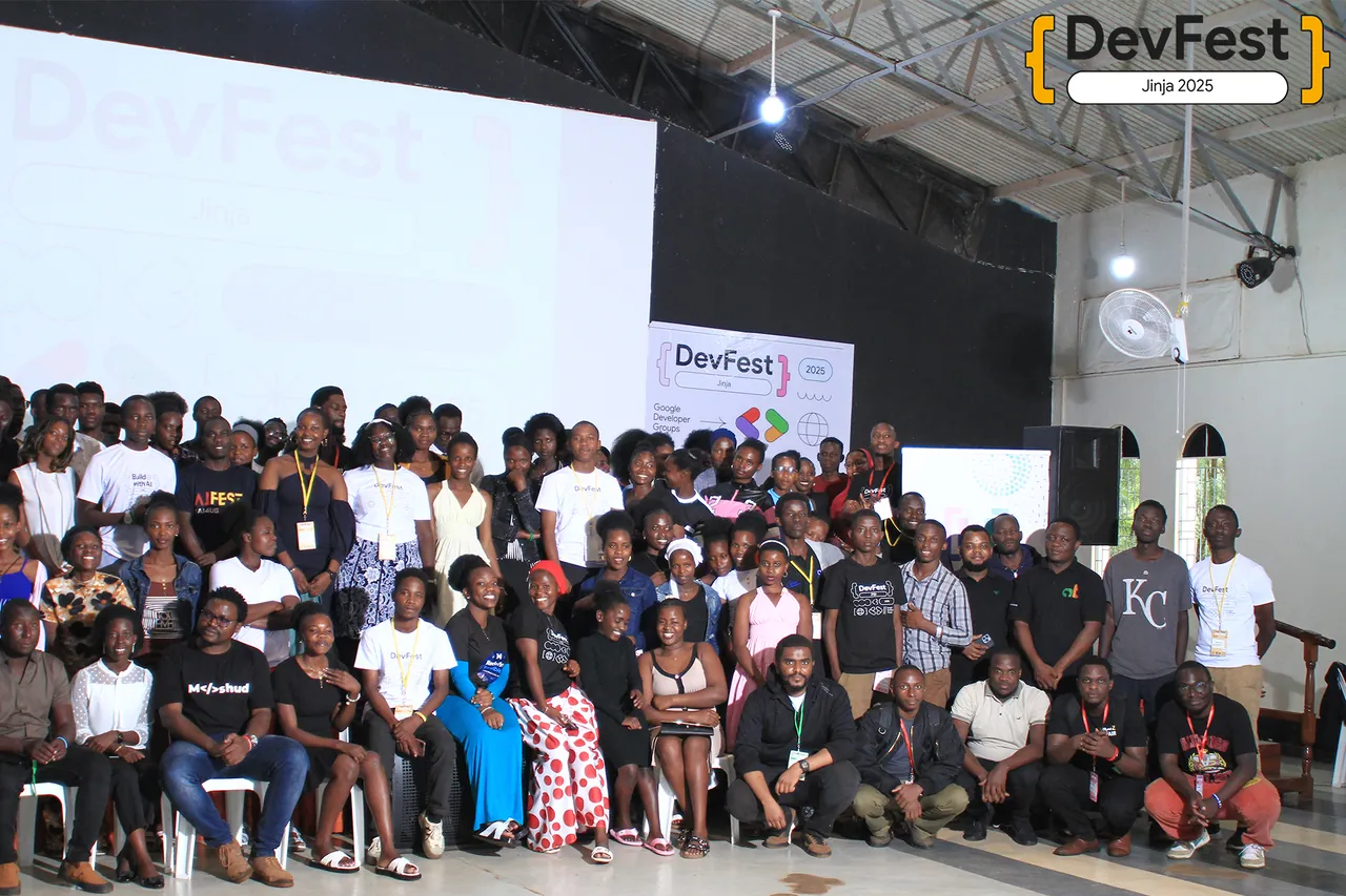 The DevFest Jinja 2025 community group photo in front of the main stage